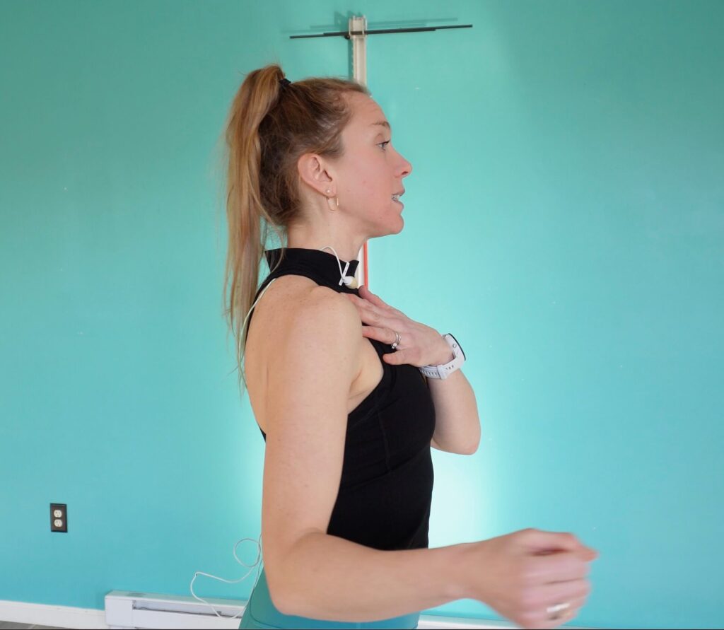 Chloe standing in a side profile showing her shoulder down and back into it's proper position to do the rotator cuff exercises